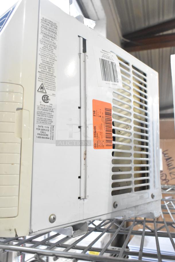 LG and Frigidaire window air conditioners, visible labels and serial numbers, used condition, metal and plastic housing.