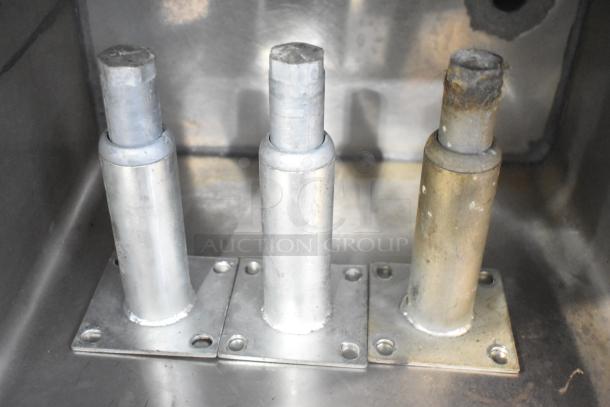 Set-n-serv Drop Ice Bin; metallic holders, three cylindrical supports, visible wear, suitable for commercial use.