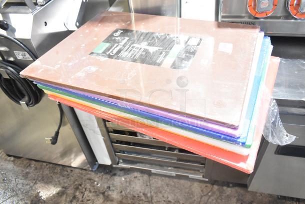 Stack of 12 brand-new Choice cutting boards, various colors, sizes 20"x15" and 24"x18", labeled "scratch and dent."