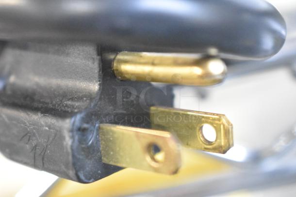 Close-up of a power plug connector for a 2025 Nemco 8045SXW-SLT hot dog roller grill, showing electrical pins and black casing.