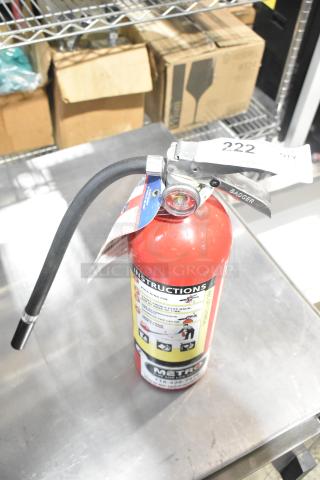 Red Badger fire extinguisher with instructional label, pressure gauge, and attached nozzle. Pickup only.