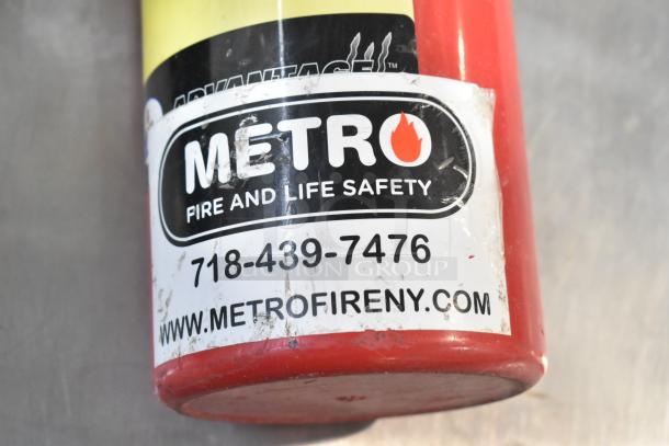 Red fire extinguisher with "Metro Fire and Life Safety" label, contact number, and website. Buyer pickup required.