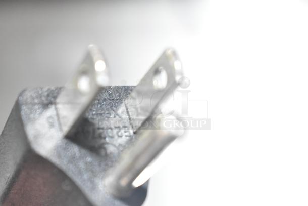 Blurred close-up of the power plug for Cooltech Commercial Single Door Chef Base, 115V, 1 Phase. Plug details visible.