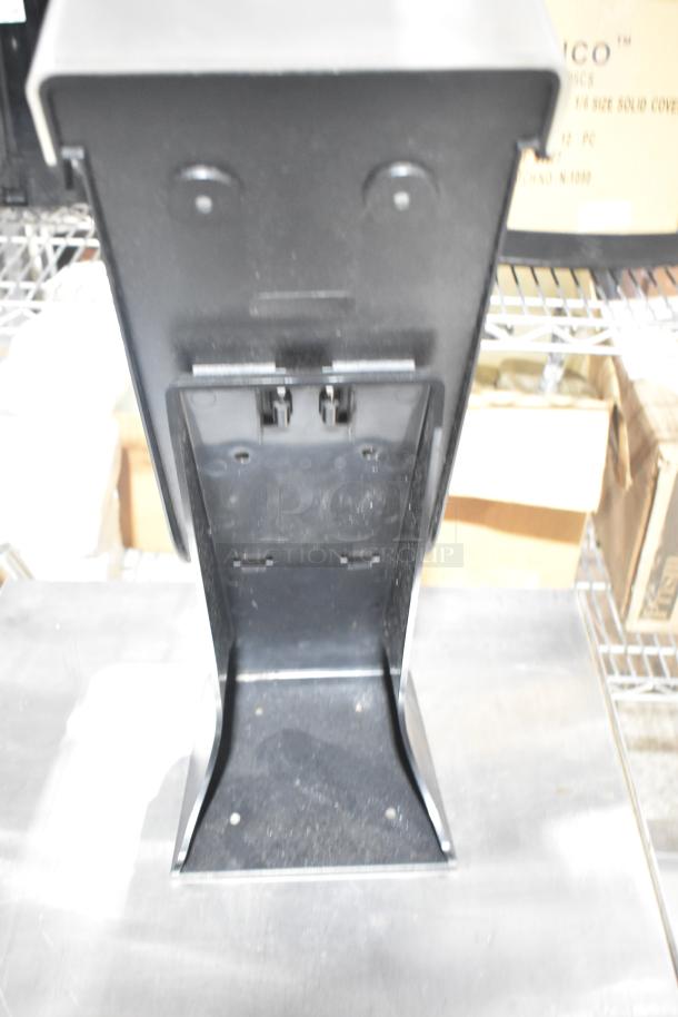 Black and clear poly countertop napkin dispenser. Sturdy design, suitable for commercial use. Clean, minimal wear visible.