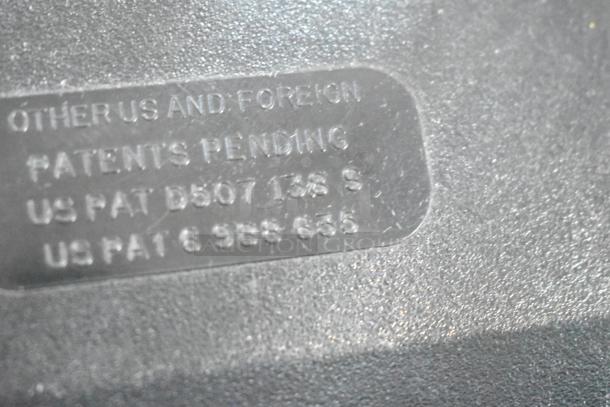 Close-up of label with patent details on black and clear poly countertop napkin dispenser. Patent pending texts visible.