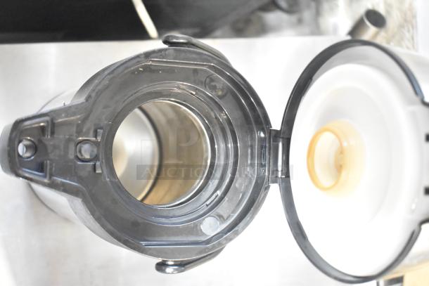 Open lid view of a Hamilton Beach beverage dispenser. Features durable black and silver construction. Ideal for auctions.