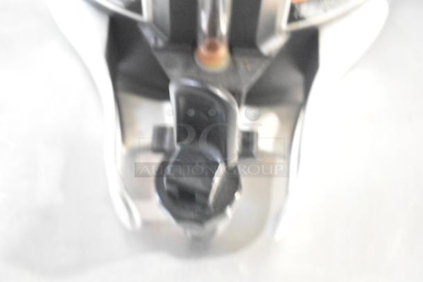 Blurry image of a beverage dispenser part and tap mechanism; details unclear and labels not visible.