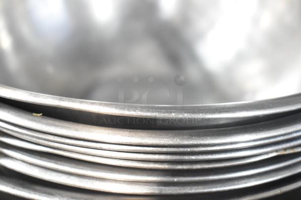 Stacked metal bowls, shiny finish, part of 18-item auction lot, minor wear visible, versatile for kitchen use.