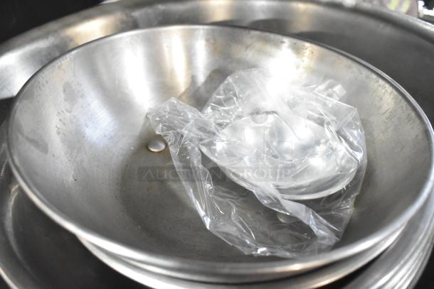 Set of metal bowls, various sizes, used condition, slight tarnish visible. Includes plastic-wrapped items, 18 total.