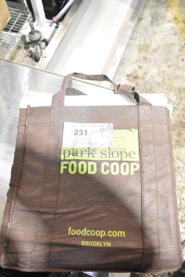 Brown tote bag with "Park Slope Food Coop" logo, holding various items including records, visible auction tag marked "231 V-lot".