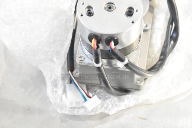 Royal Kincool FL57BLS01-24V-4000AD-01 round motor, new, with visible wires and connectors, wrapped in bubble wrap.