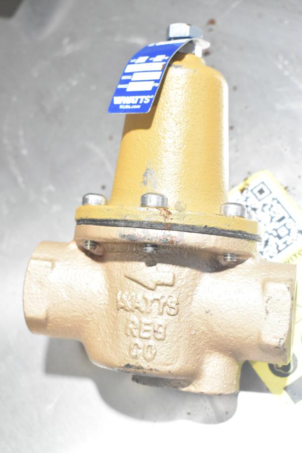 Watts unit with brass body, visible blue tag, and embossed logo, showing signs of wear. Part of a 5-item auction lot.