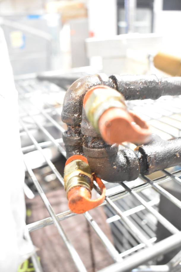 Five industrial items including a Watts unit and pipe with Ansul tips on a metal shelf, used condition.