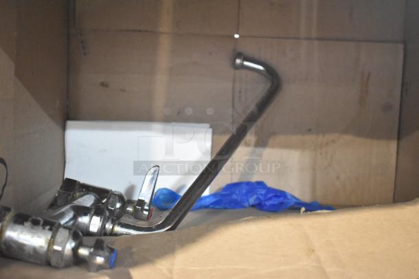 Stainless steel faucet with curved spout and dual handles, showing signs of wear. Ideal for restoration projects.