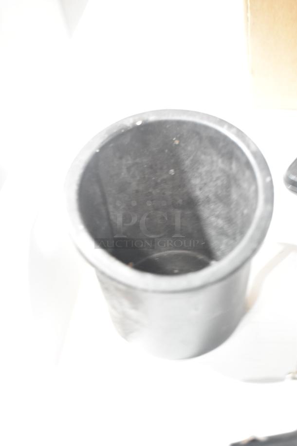 Black rubber cylindrical cup holder, slightly used, with minor scuffs. Part of 4-item auction including 3 Garmin GPS units.