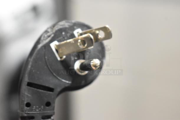 Close-up of a power plug for the Samsung RZ11M7074SA cooler freezer, showing a grounded three-prong plug.