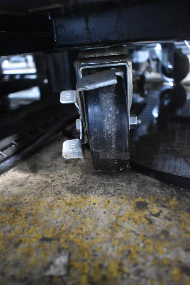 Close-up of heavy-duty commercial caster on 2018 True T-35-HC cooler. Caster shows wear. Part of 115V, 1-phase system.