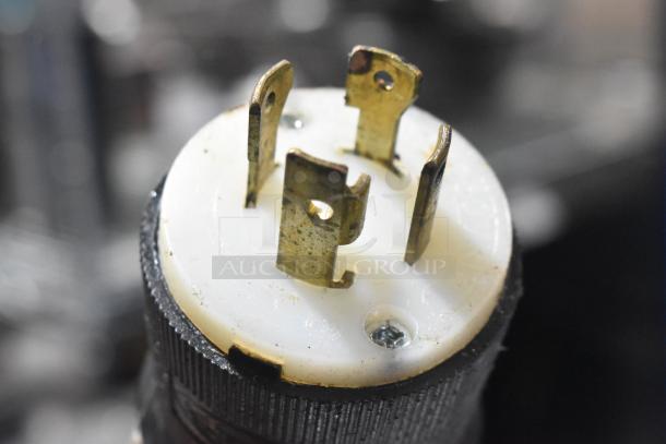 Close-up of Middleby Marshall CTX DZ33I plug showing four metal prongs and white base; part of electric conveyor pizza oven.