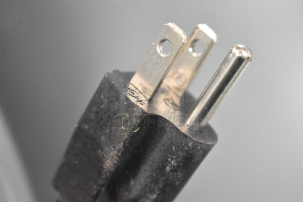 Close-up of a power plug for Frigidaire EFR840-MINT-6COM Mini Cooler. Shows three prongs and black casing.