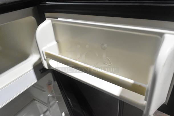 Magic Chef HMDR310SE mini cooler interior, showcasing freezer compartment. Model features durable shelving.