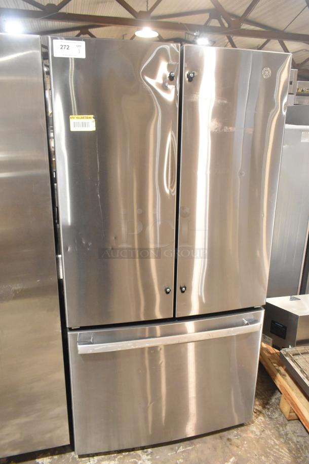 GE GNE27JYMYFFS refrigerator with freezer drawer, stainless steel finish, minor surface dents, label shows 115V, 1 Phase.