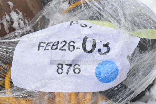 Plastic-wrapped item labeled "FEB26-03 876," includes a new scratch-and-dent floor cleaning machine, ready for auction.