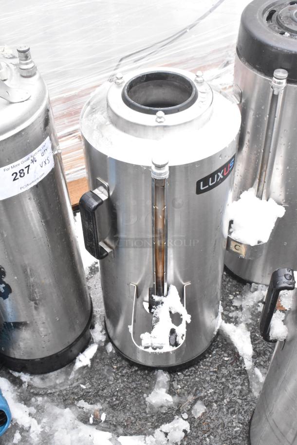 Five Fetco Luxus beverage dispensers, including model TPD-15, stainless steel, with visible handles and Luxus branding.