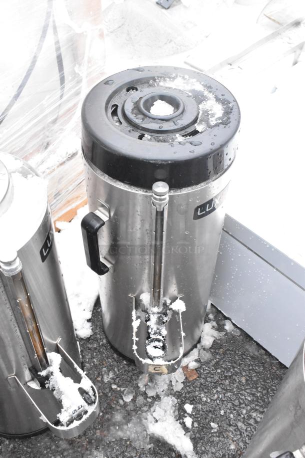 5 Fetco Luxus beverage dispensers, including TPD-15 model. Stainless steel, snow-covered, outdoor condition.