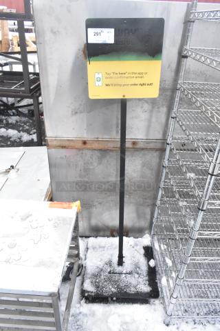 Metal sign on a pole with snow, featuring a pickup instruction label. Some wear visible. Auction tag reads "291".