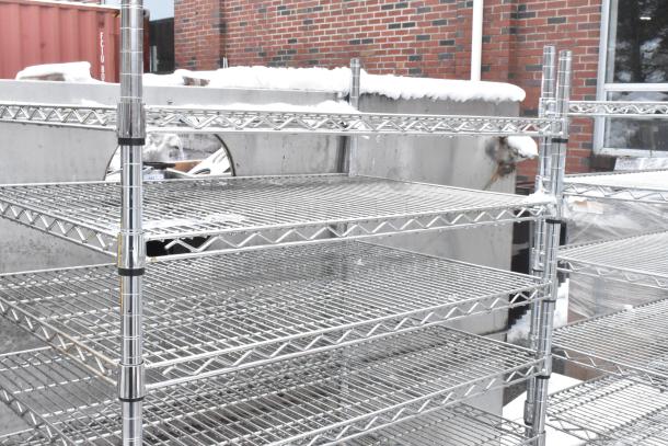 Chrome finish 10-tier wire shelving unit, in outdoor setting, snow-covered. Needs dismantling; buyer responsible for freight.