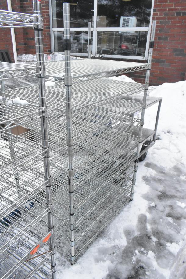 Chrome finish 9-tier wire shelving unit in snow, requires dismantling for transport, visible warehouse setting.
