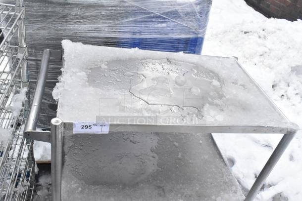 2-tier stainless steel cart with commercial casters, lightly snow-covered, metal frame, label indicates "295" ID number.