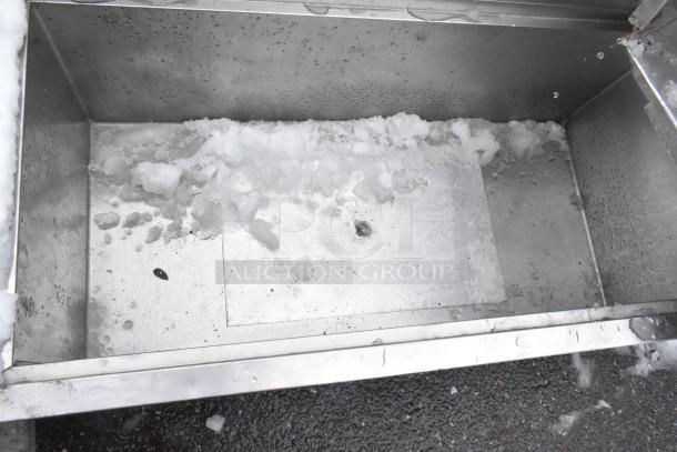 Commercial ice bin with metallic interior, partially filled with ice. Appears to be in used condition. No visible labels.