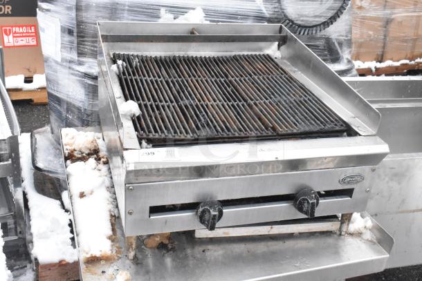 Commercial countertop charbroiler grill on equipment stand, stainless steel, two control knobs, light rust, snow residue.