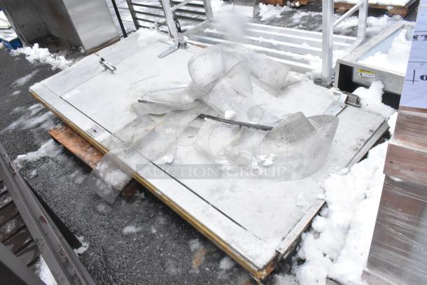 Industrial walk-in door with frame, metal construction, surface wear from snow exposure, includes mounting hardware.