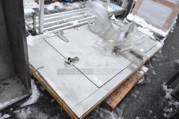 Walk-in door with frame, metal construction, visible latch and hinge. Slight wear, minor snow residue, suitable for industrial use.