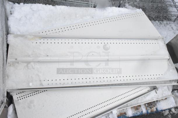 Pallet lot of white metal shelves, snow-covered, with perforated design, outdoor setting, shows wear but functional.