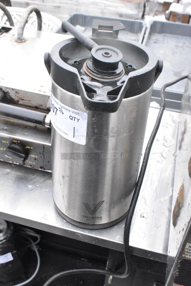 Stainless steel air pot missing lid, with visible Vondior logo and auction tag, showing signs of use.