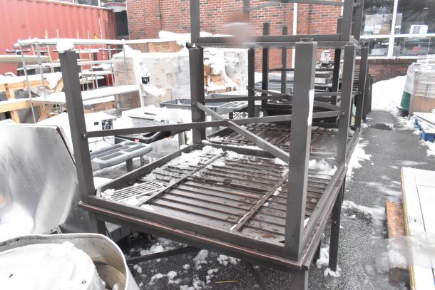 Five stacked brown outdoor patio tables, metal frames, used condition, visible snow and outdoor storage marks.