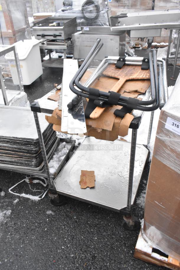 Metal table with under shelf on commercial casters, includes tray stands. Visible wear, rust on wheels, and surrounding equipment.