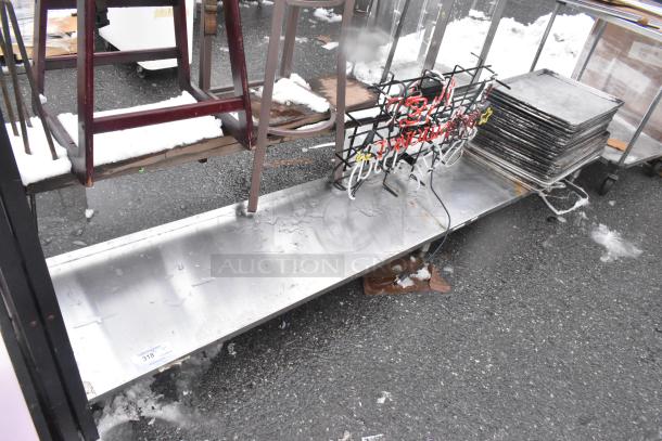 Metal shelf with snow, neon sign, numerous stacked metal baking pans. Item label "318" visible. Used condition.