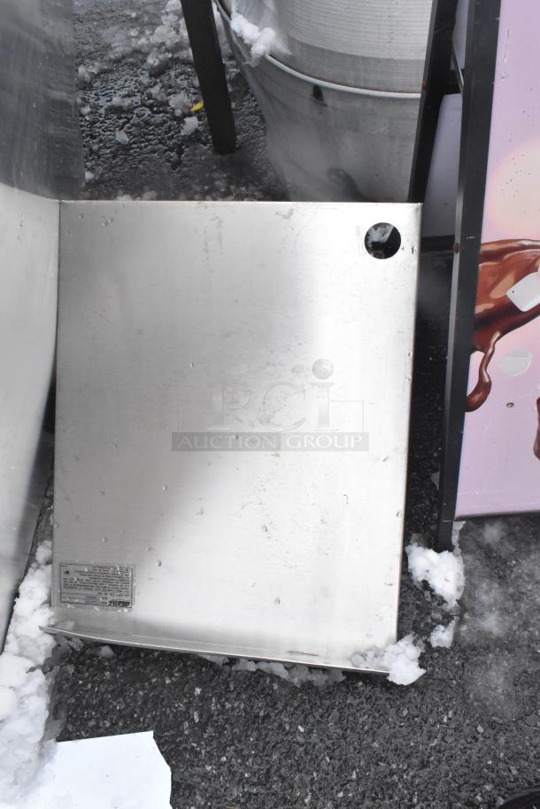 Aluminum panels, slightly weathered, with visible hole and manufacturer's label, resting on snowy pavement.