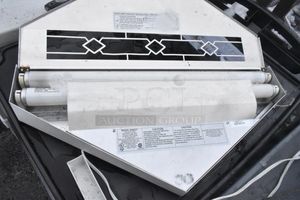 Bug zapper with metal casing, fluorescent tubes, and decorative front panel. Labels indicate Model 2000GT and caution instructions.