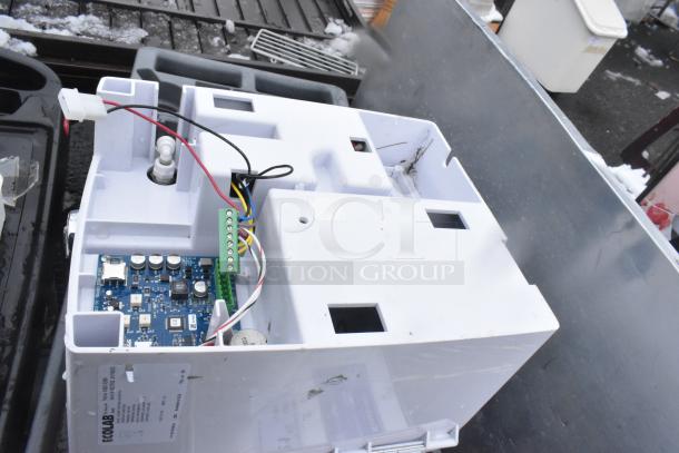 Ecolab Water Booster with open casing, showing internal electronics and wiring, placed on a metallic surface, slightly used.