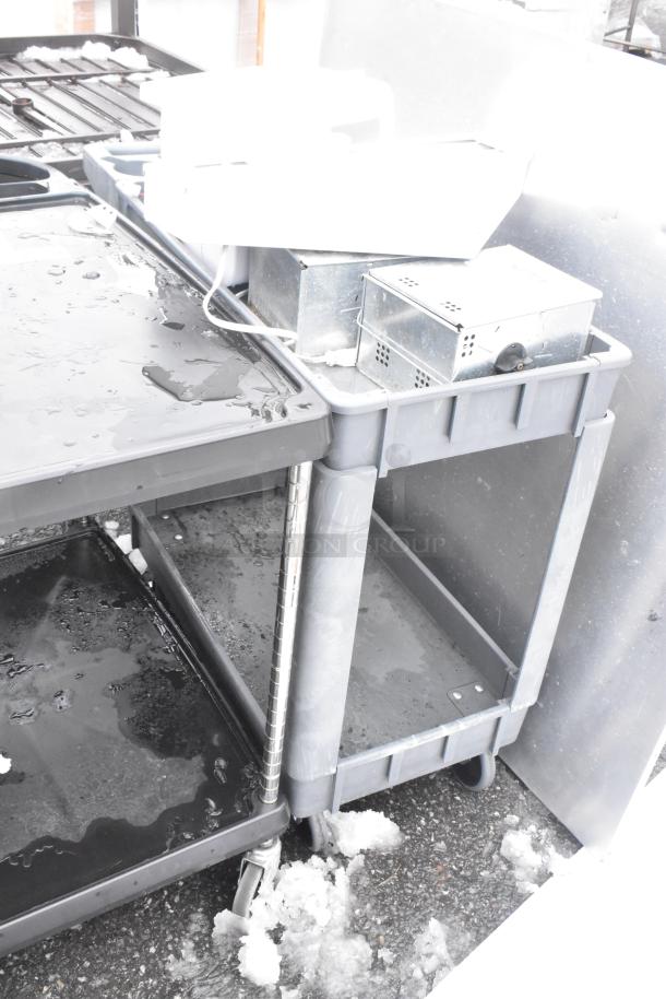 Three gray poly two-tier carts on commercial casters, lightly used, featuring durable construction, ideal for heavy-duty use.