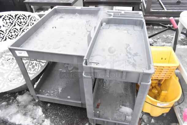 Gray 2-tier poly cart on commercial casters, visibly wet, used condition. Tag marked "324." Ideal for storage or transport.
