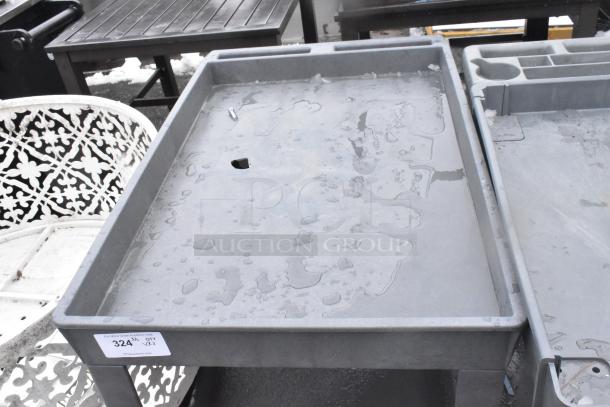 2-tier poly cart with commercial casters, shown outdoors. Includes label with lot number "324." Some water on surface.