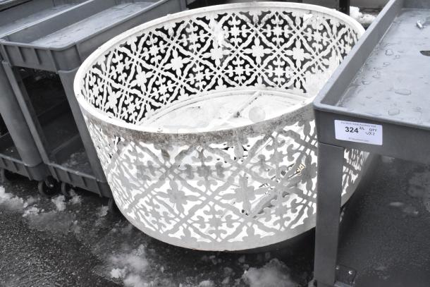 Decorative white metal bin with intricate cut-out floral design, exhibiting slight wear; auction tag showing lot number 324.