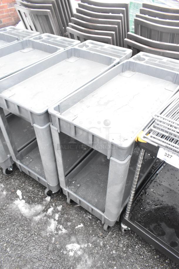 2 Poly 2 Tier Carts on commercial casters, gray, durable plastic, in good condition, ideal for heavy-duty use.