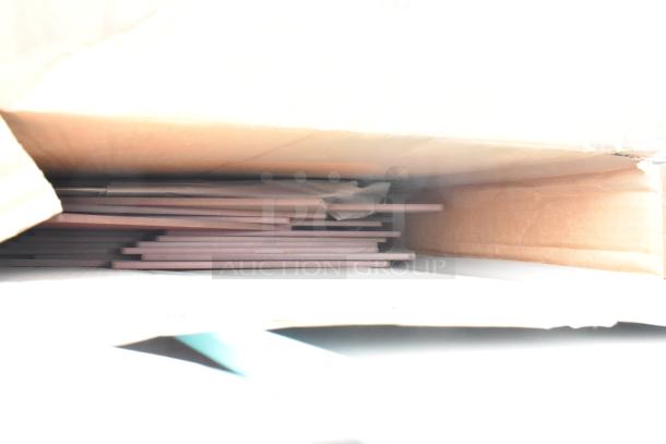 Cardboard box containing multiple flat items, possibly trays, stacked inside; part of a scratch and dent lot.